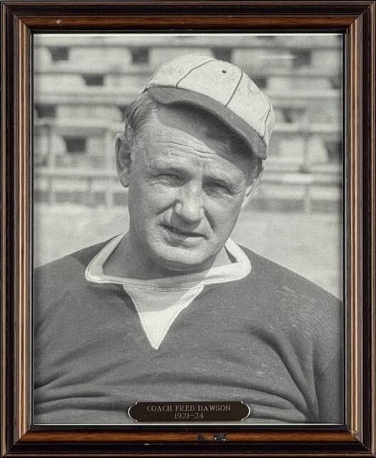 Black-and-white portrait of Fred Dawson in a striped cap, the stadium stands behind him.
