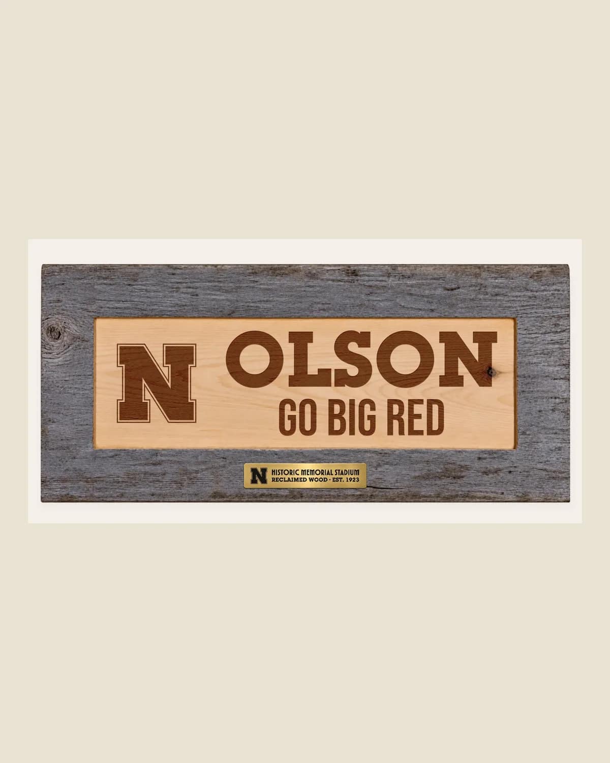 A Memorial Stadium wood sign engraved OLSON and GO BIG RED beside the Nebraska N.